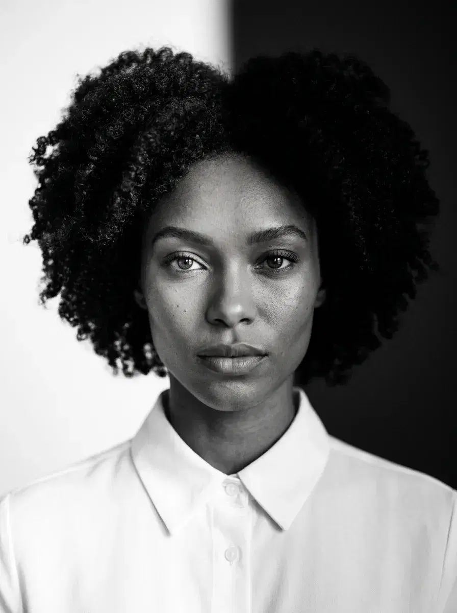 AI AI Black and White Noir Photos — Dark Glamour — Chest-up split-lighting noir portrait, half face in shadow, sharp black and white editorial